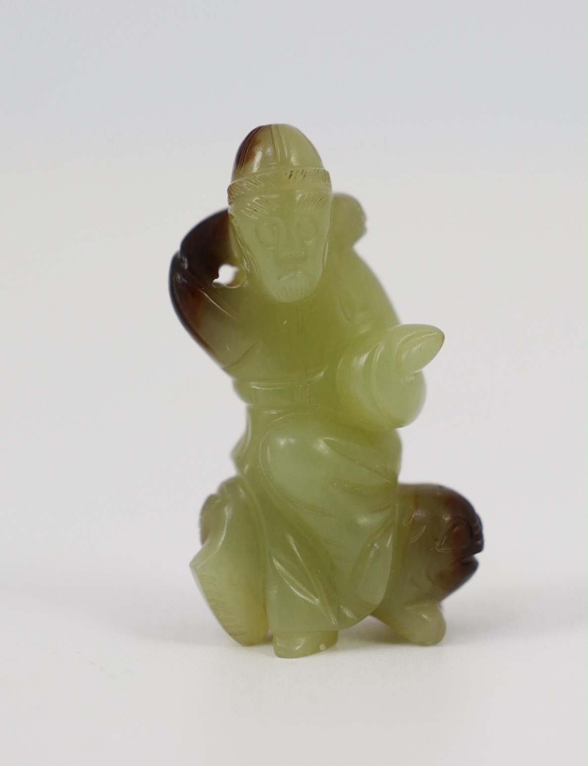 A Chinese yellow and brown jade figure of a man seated on a creature, 19th century, 4.3cm high
